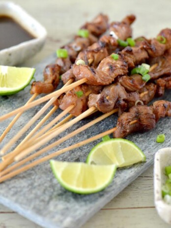 Slice tenderloin in half lengthwise. On a working surface, place in a large gallon plastic bag or cover with plastic wrap. Pound with a meat mallet to approximately ¼-inch thick. Slice into 5”x1” strips. Soak skewers in water for a minimum of 30 minutes. Combine soy sauce, sugar, lime juice, olive oil peanut butter, garlic and green onions in a large gallon-size sealable plastic bag. Seal and shake to mix all ingredients. Add pork tenderloin strips and seal bag. Press and shake bag, making sure all ingredients have incorporated. Refrigerate for 2 hours. Remove from bag and discard marinade. Preheat grill to medium high. Thread 1-3 tenderloin strips with bamboo skewers and carefully place on grill. Cook for 3-4 minutes on each side. Remove from grill onto a serving platter and cover with aluminum foil. Let rest for 3 minutes before serving. To prepare ginger dipping sauce: Combine all sauce ingredients in a jar with lid. Shake well to combine. Serve skewers with dipping sauce.